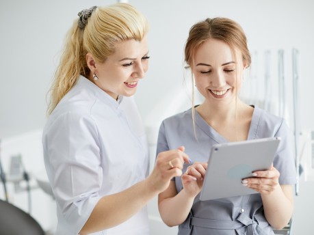 Ärztin und ZFA schauen auf ein Tablet